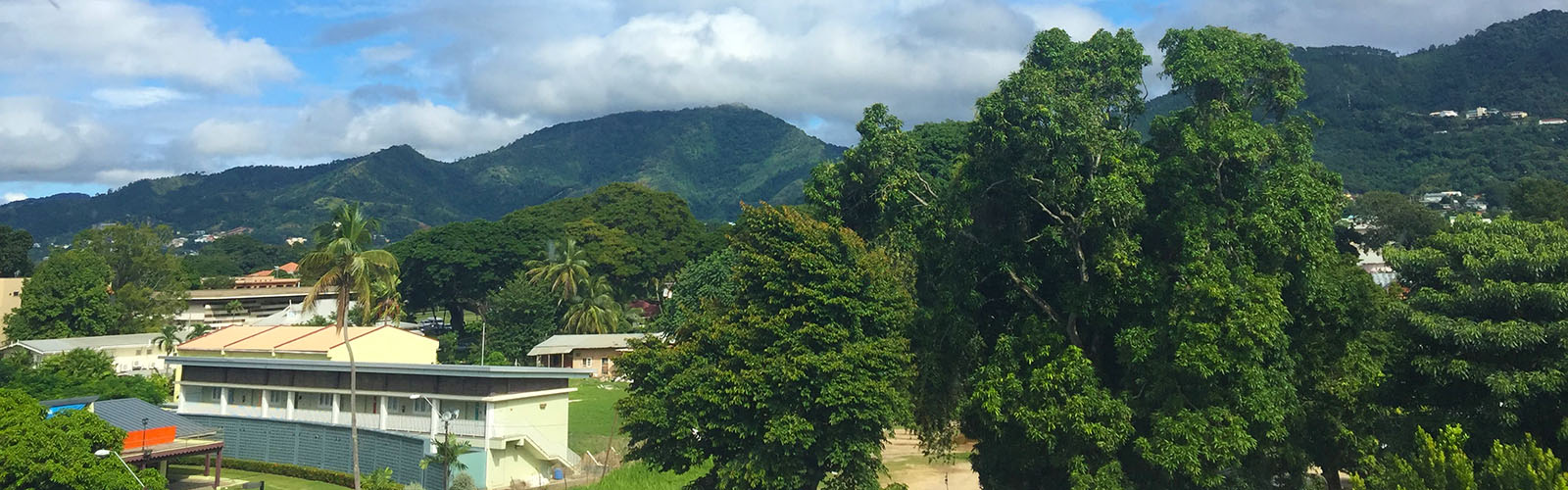 Scattered buildings with large hills in the background.